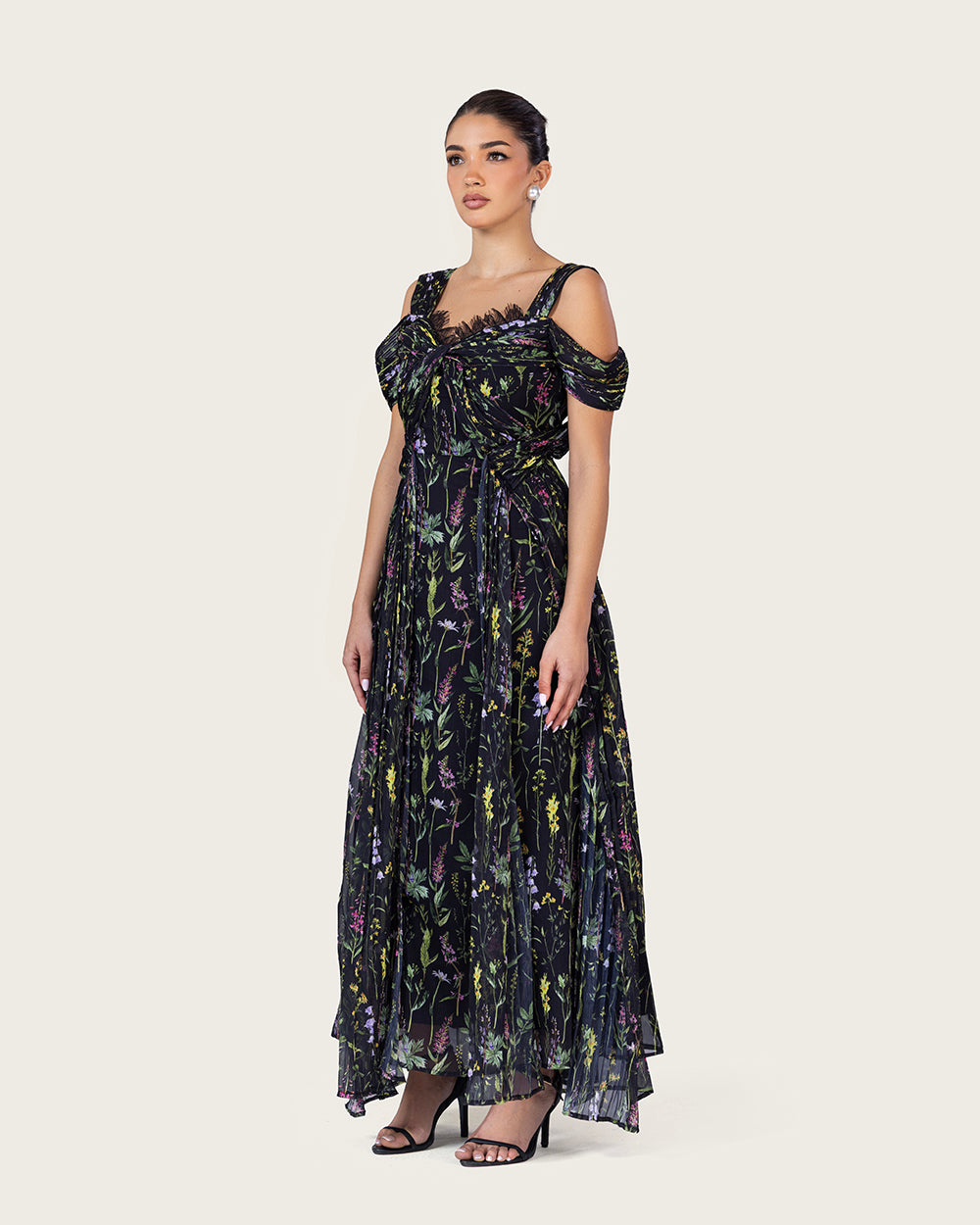 فستان ماكسي أسود بطبعة زهرية وتصميم كتف مفتوح أنيق
