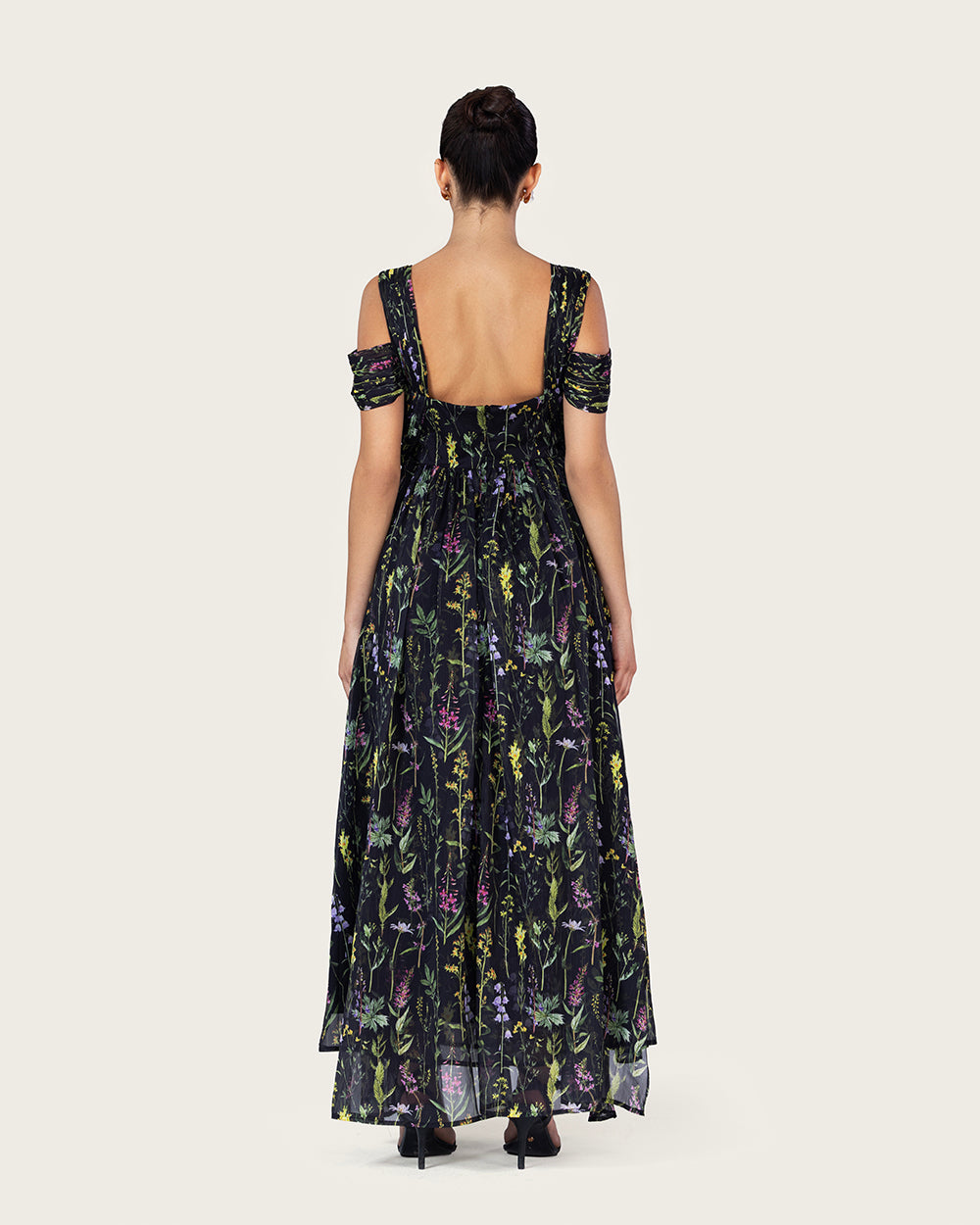 فستان ماكسي أسود بطبعة زهرية وتصميم كتف مفتوح أنيق