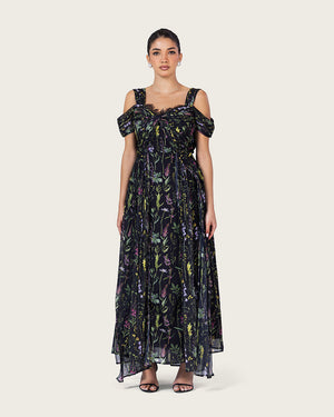 فستان ماكسي أسود بطبعة زهرية وتصميم كتف مفتوح أنيق