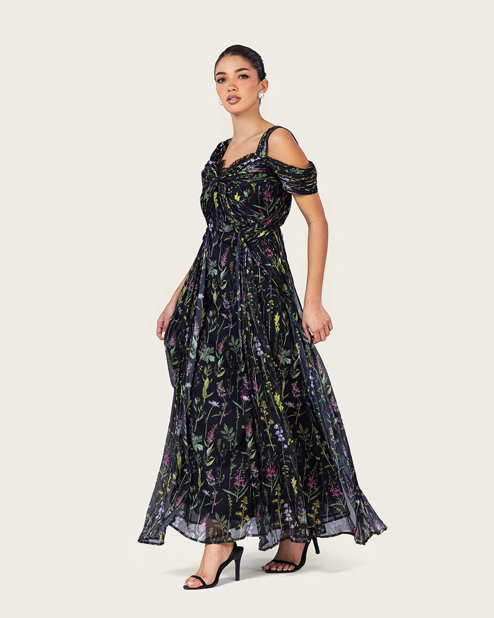 فستان ماكسي أسود بطبعة زهرية وتصميم كتف مفتوح أنيق