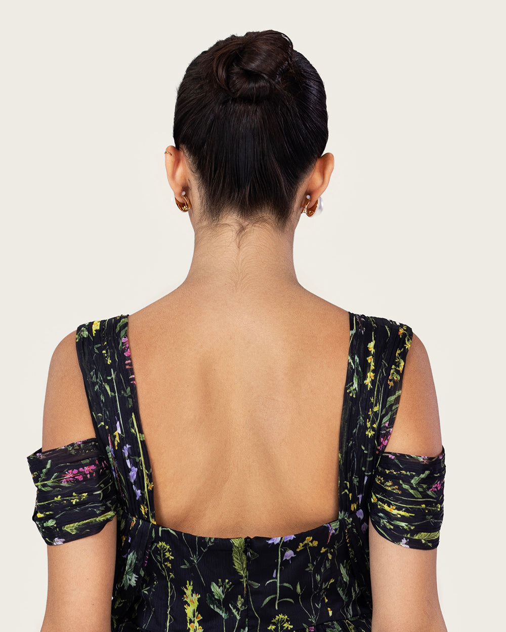 فستان ماكسي أسود بطبعة زهرية وتصميم كتف مفتوح أنيق