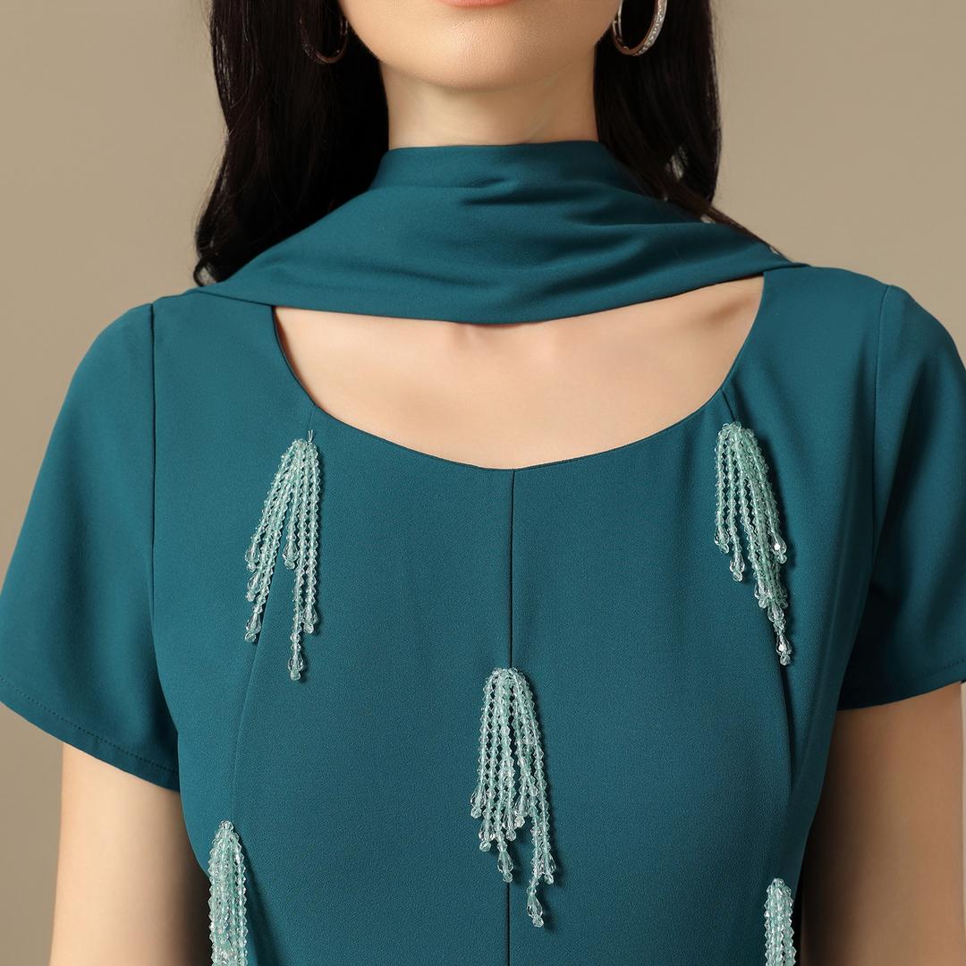 فستان ماكسي أخضر بترولي بتطريز خرزي وقصّة مستقيمة