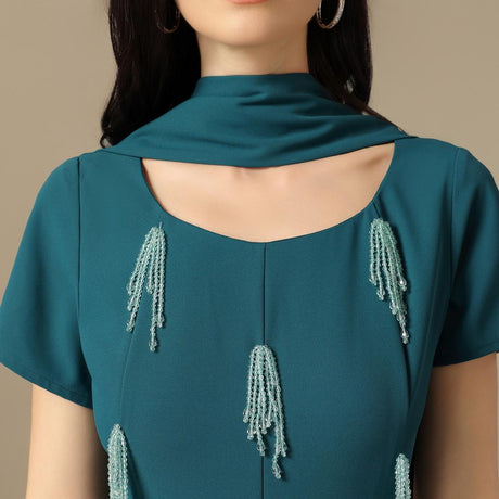 فستان ماكسي أخضر بترولي بتطريز خرزي وقصّة مستقيمة